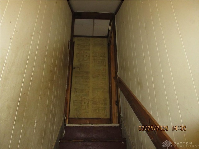 stairs featuring wooden walls