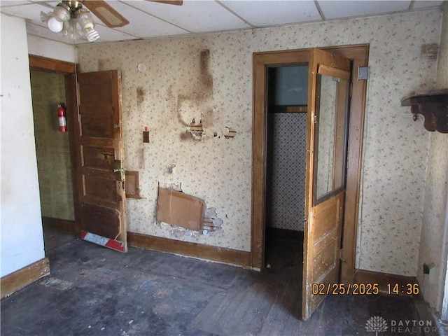 unfurnished room with baseboards, wallpapered walls, and ceiling fan