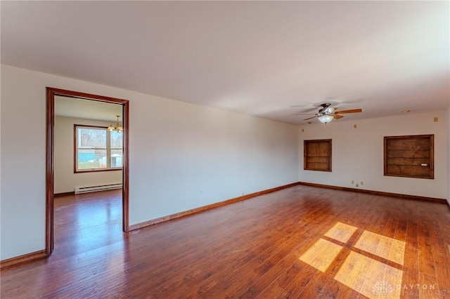 unfurnished room with baseboard heating, ceiling fan with notable chandelier, baseboards, and hardwood / wood-style floors