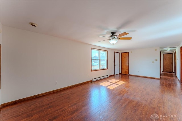 spare room featuring baseboards, wood finished floors, a ceiling fan, and a baseboard radiator