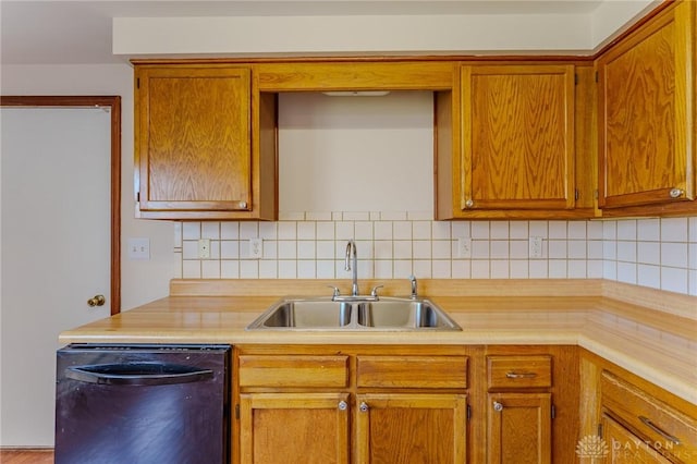 kitchen featuring tasteful backsplash, dishwasher, light countertops, brown cabinets, and a sink