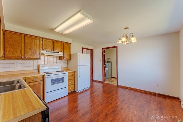 kitchen featuring under cabinet range hood, tasteful backsplash, water heater, white appliances, and light countertops