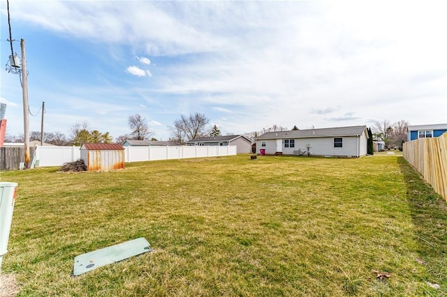 view of yard with an outdoor structure, a storage unit, and a fenced backyard