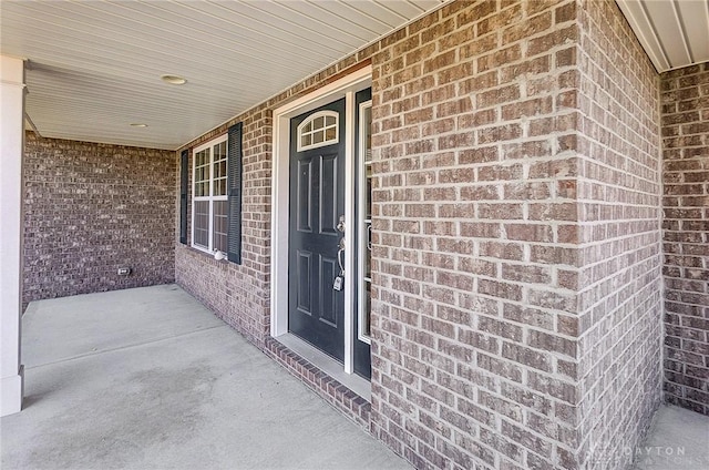 property entrance with brick siding and covered porch