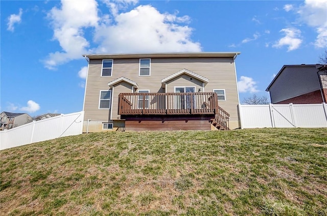 rear view of house with a fenced backyard, a deck, a yard, and a gate