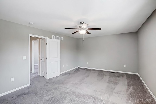 unfurnished room with carpet flooring, a ceiling fan, visible vents, and baseboards