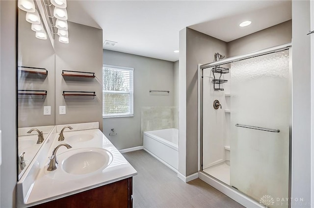 full bathroom with a sink, a garden tub, a stall shower, and double vanity