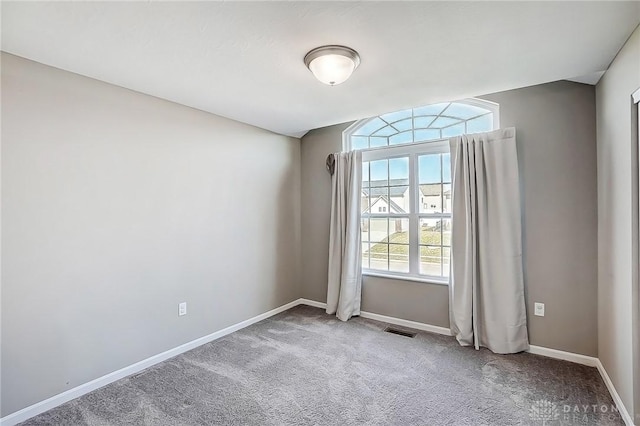 spare room with visible vents, carpet flooring, and baseboards