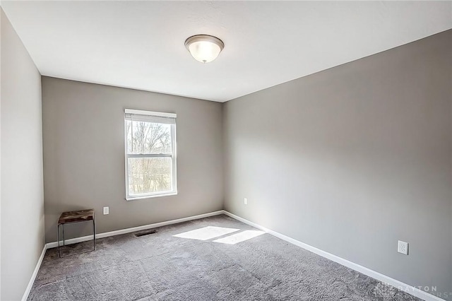 empty room featuring visible vents, carpet flooring, and baseboards