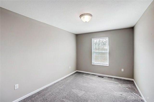 carpeted empty room featuring visible vents and baseboards