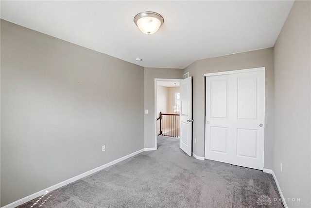 unfurnished bedroom with carpet, baseboards, and a closet