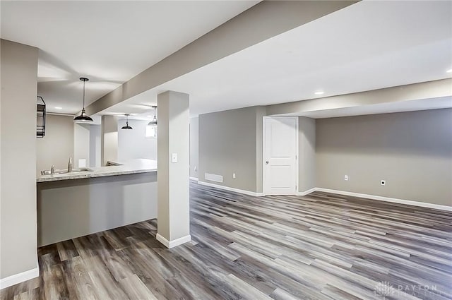 interior space with visible vents, wood finished floors, baseboards, and a sink