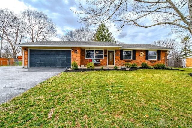 ranch-style home featuring brick siding, fence, aphalt driveway, a front yard, and an attached garage