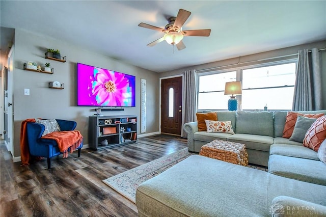 living area featuring wood finished floors, baseboards, and ceiling fan