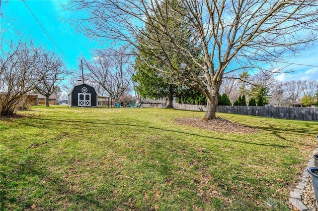 view of yard with a barn, an outdoor structure, and fence