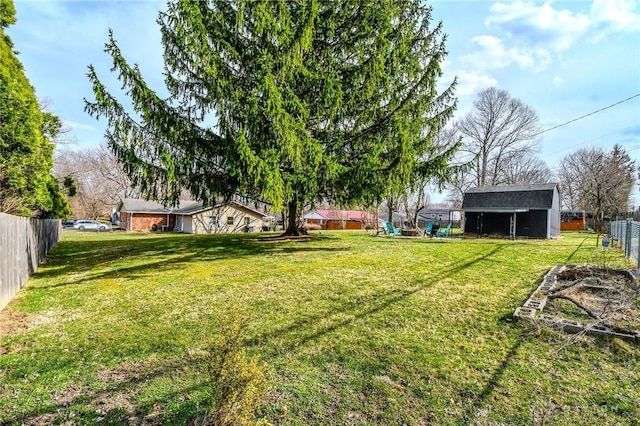 view of yard featuring an outbuilding, a playground, and fence