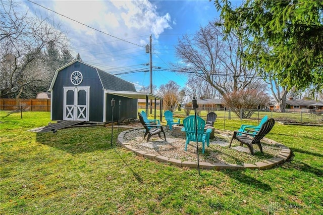 view of yard with an outdoor structure, a storage shed, a fenced backyard, and an outdoor fire pit