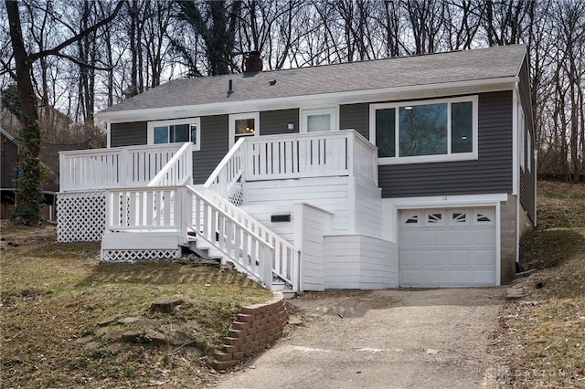 view of front of home featuring an attached garage, stairs, roof with shingles, a chimney, and driveway