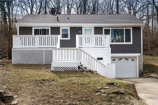 view of front of house featuring stairway, roof with shingles, an attached garage, a chimney, and concrete driveway