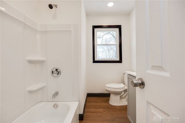 bathroom with shower / tub combination, toilet, wood finished floors, and baseboards