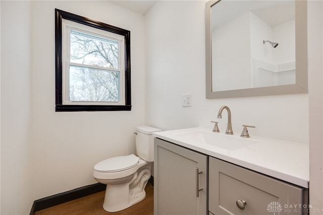 bathroom with vanity, toilet, wood finished floors, and walk in shower