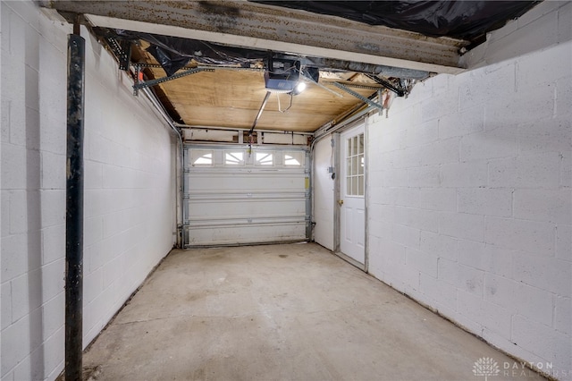 garage featuring concrete block wall and a garage door opener