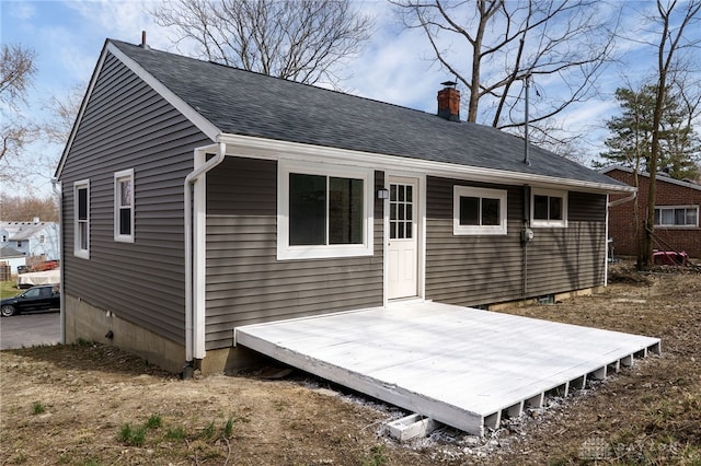 rear view of property with crawl space, a wooden deck, a chimney, and a shingled roof