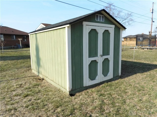 view of shed with a trampoline and fence