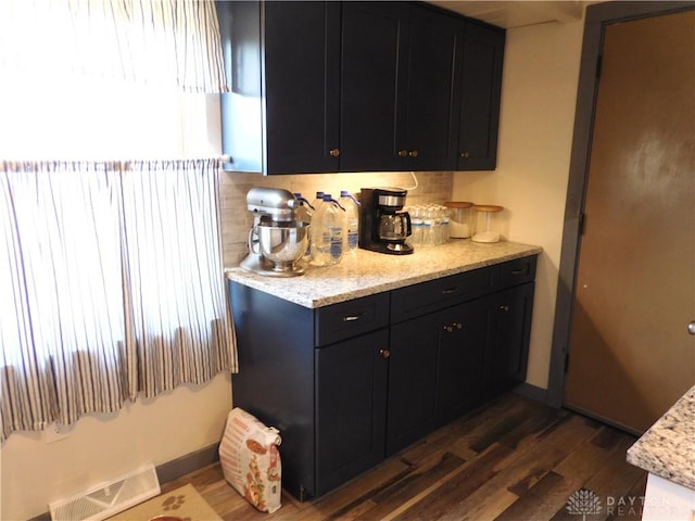 kitchen featuring decorative backsplash, visible vents, dark cabinets, and dark wood-style flooring