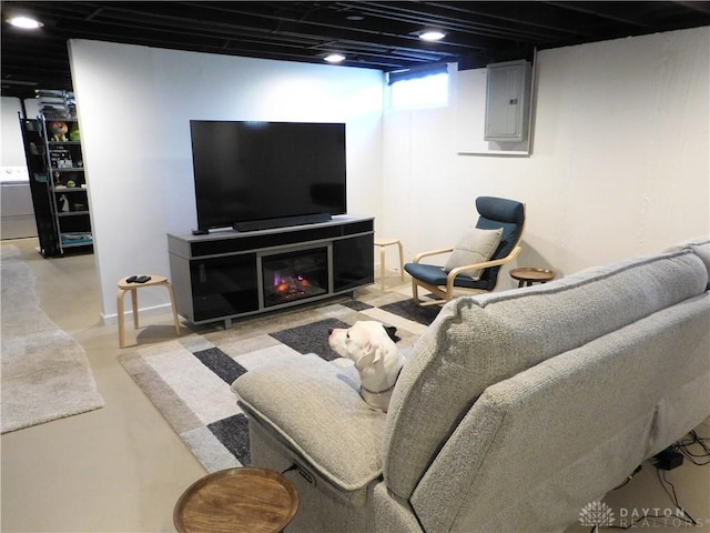 living area featuring electric panel and finished concrete floors