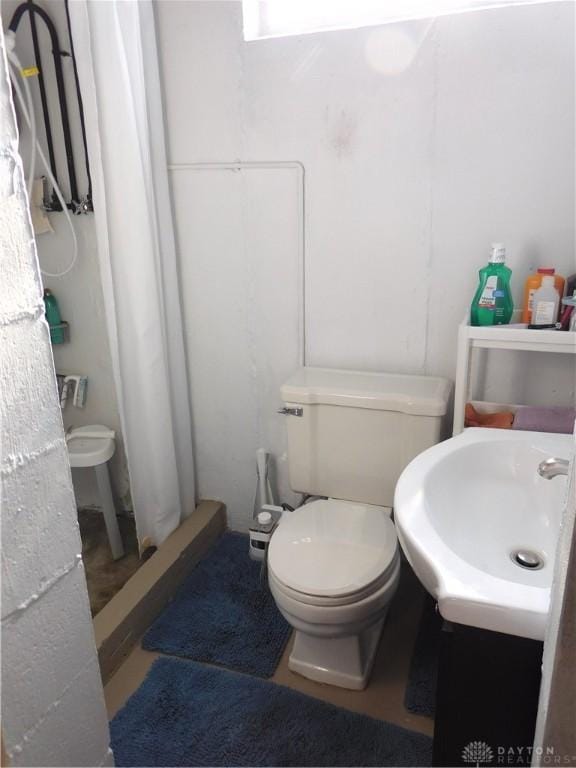 full bath with a stall shower, toilet, and vanity