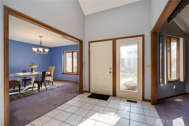 foyer featuring visible vents, baseboards, a chandelier, light carpet, and light tile patterned floors