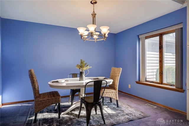 carpeted dining area with an inviting chandelier, baseboards, and visible vents