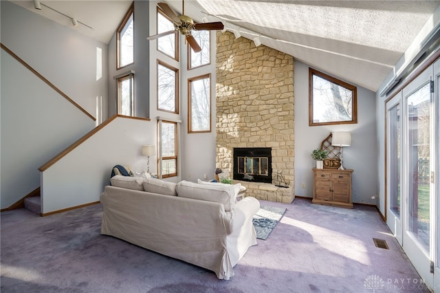 living room with visible vents, rail lighting, carpet flooring, baseboards, and ceiling fan