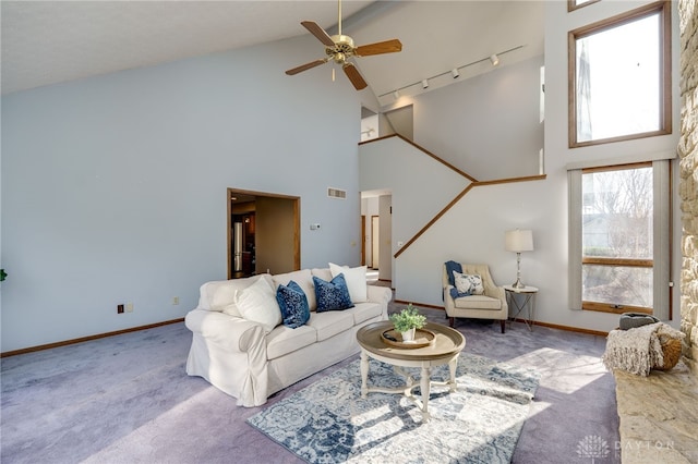 carpeted living room featuring visible vents, baseboards, track lighting, and a ceiling fan