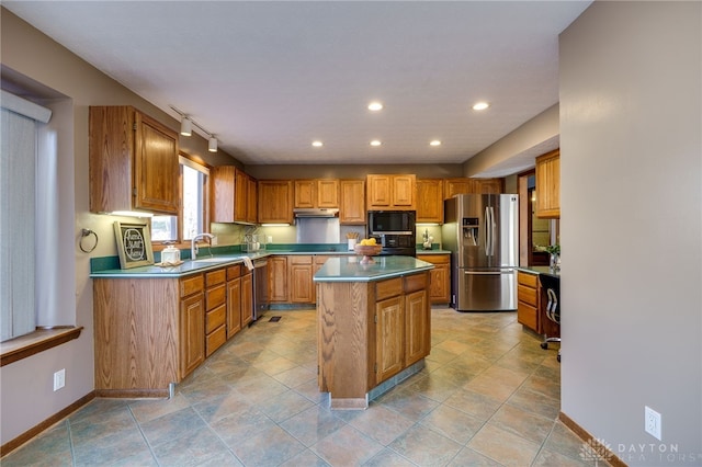 kitchen with a kitchen island, baseboards, under cabinet range hood, recessed lighting, and stainless steel appliances