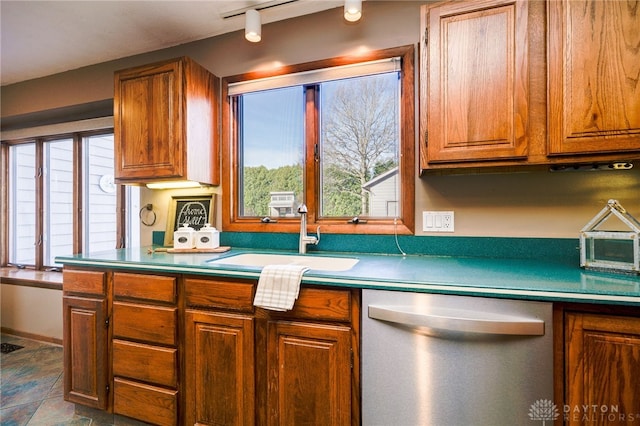 kitchen with brown cabinetry, dishwasher, and a sink