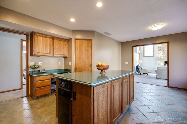 kitchen featuring dark countertops, visible vents, built in desk, and a kitchen island