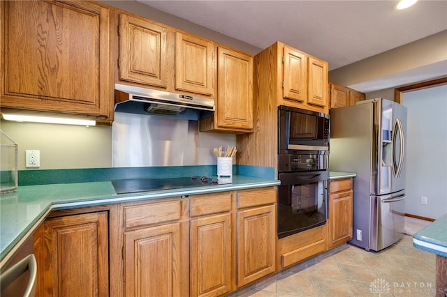 kitchen with under cabinet range hood, brown cabinets, black appliances, and light countertops