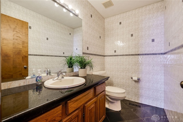 bathroom featuring visible vents, toilet, tile walls, and tile patterned flooring