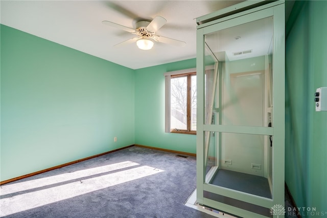 interior space featuring visible vents, baseboards, a ceiling fan, and carpet floors