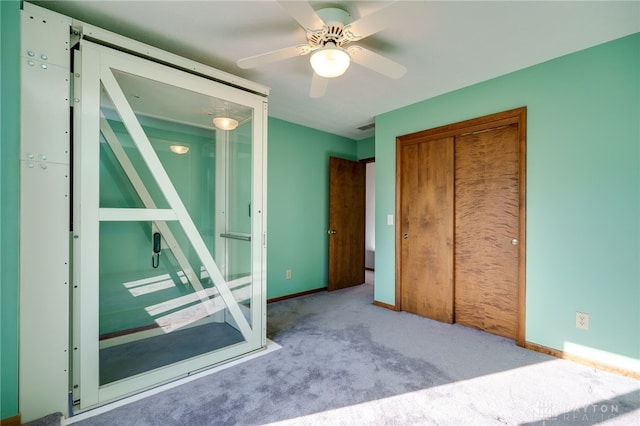 unfurnished bedroom featuring a closet, baseboards, carpet, and a ceiling fan