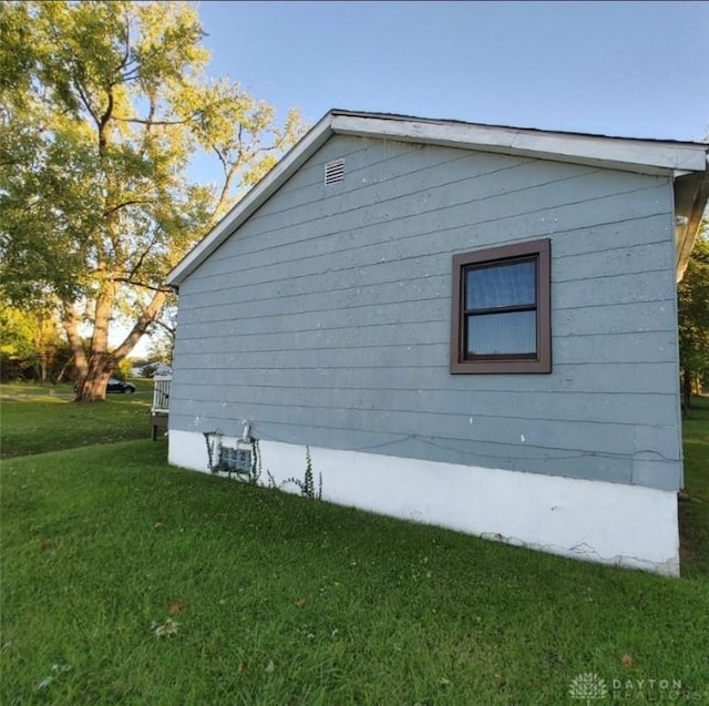 view of side of home with a yard