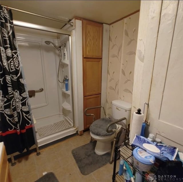 full bath featuring a shower stall and toilet