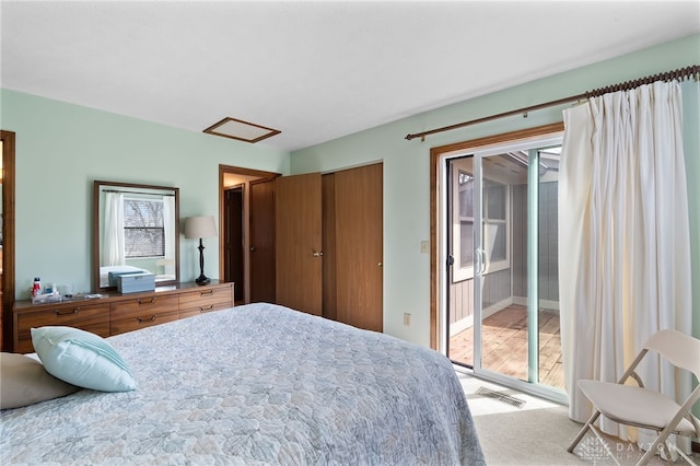 carpeted bedroom featuring visible vents, attic access, and access to exterior