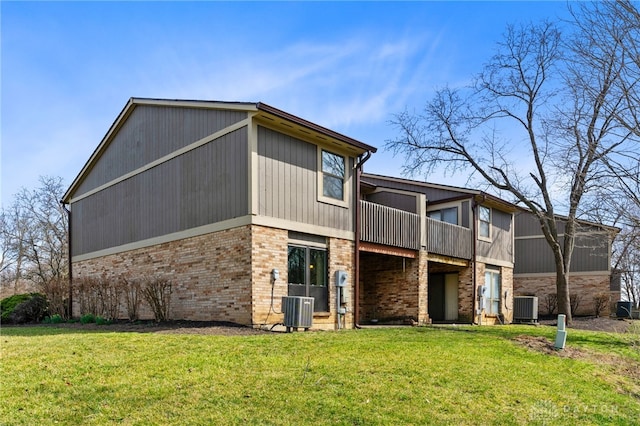 rear view of property with a lawn, central AC unit, and a balcony