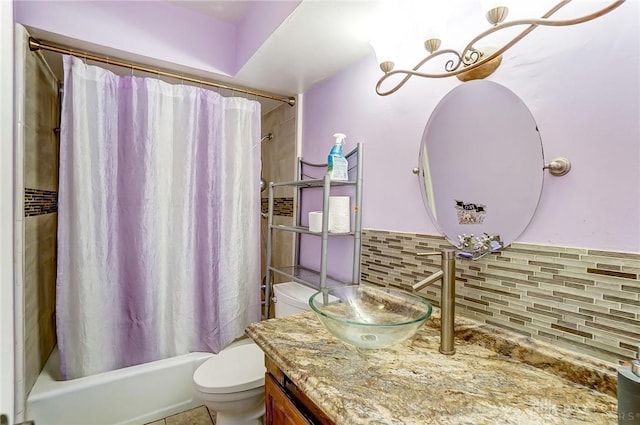 bathroom featuring backsplash, toilet, shower / tub combo with curtain, an inviting chandelier, and vanity