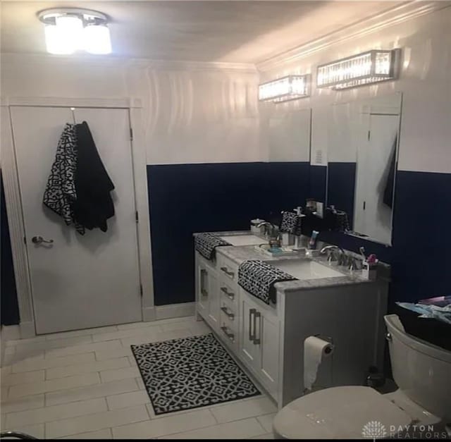 bathroom featuring vanity, toilet, and crown molding