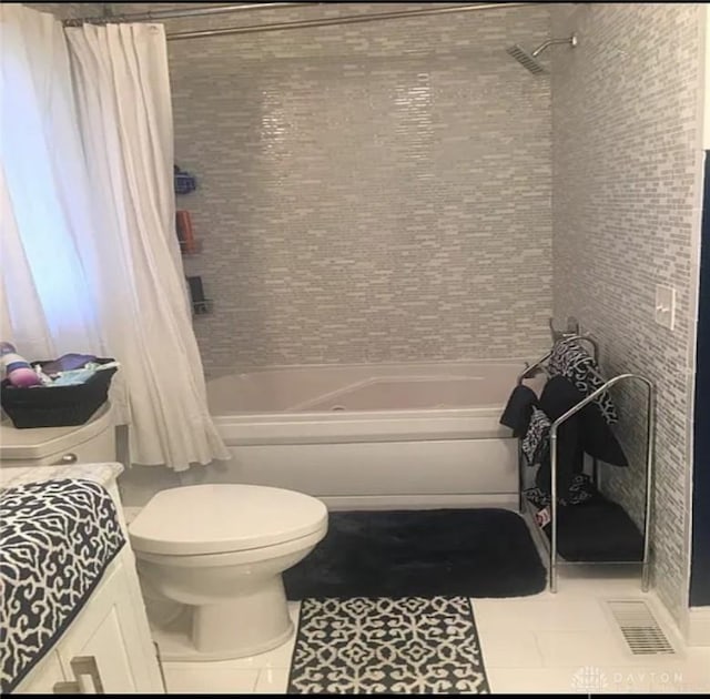 bathroom featuring tile patterned flooring, shower / tub combo, and toilet