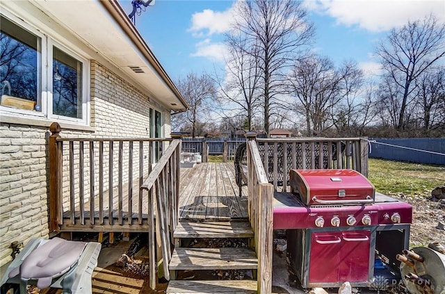 deck with a grill and fence